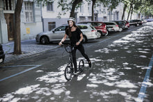 Woman riding Yedoo S1616 kick bike, scooter through street